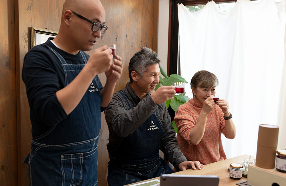 ブルーベリーのドリンクを飲むさがみこファームの山川さん・小出さん、フレックスのいずみ社長