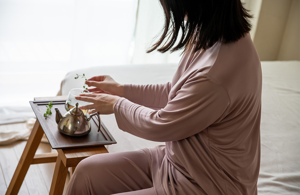 パジャマを着てお茶を入れる様子　パジャマ屋IZUMM シルクニットパジャマ