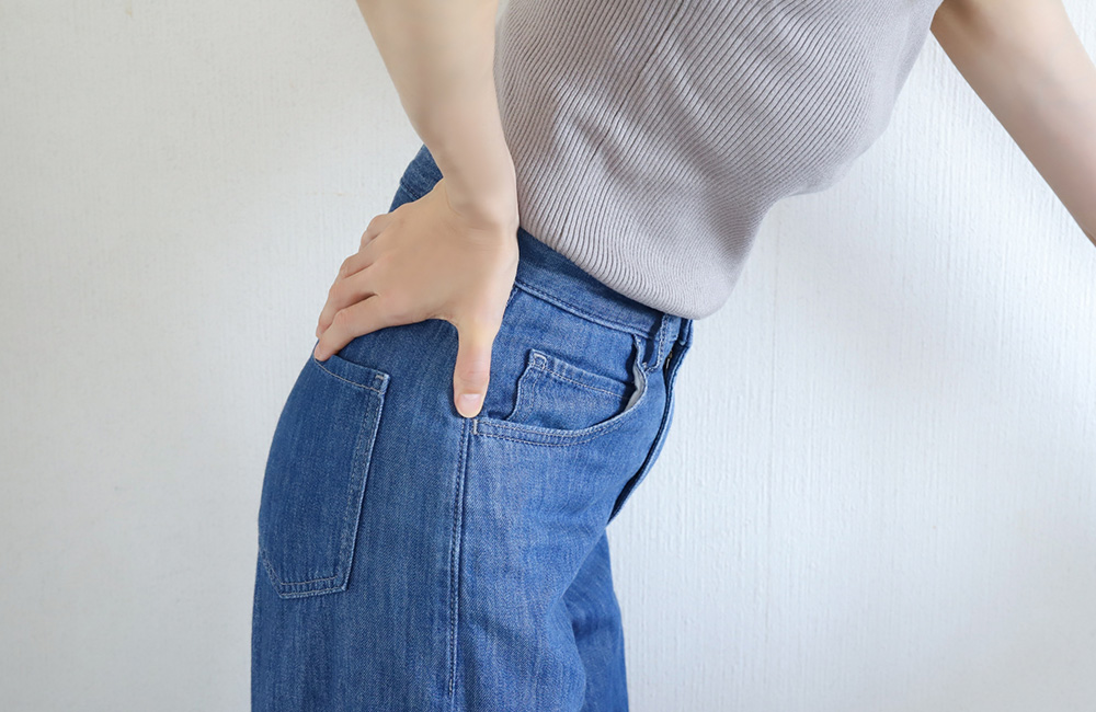 産後のママにお疲れ様を　産後辛い体　関節痛　腰痛　腹痛　で腰を抑える女性