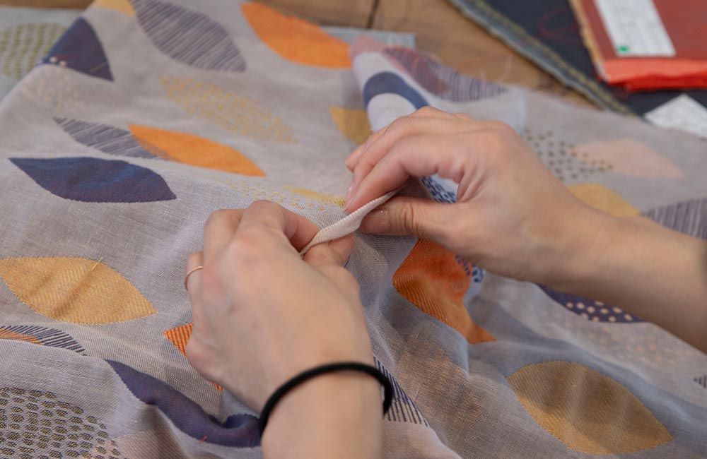 パジャマ屋IZUMM 今治3重ガーゼ ジャガード織りパジャマ リーフ柄の生地を触る様子